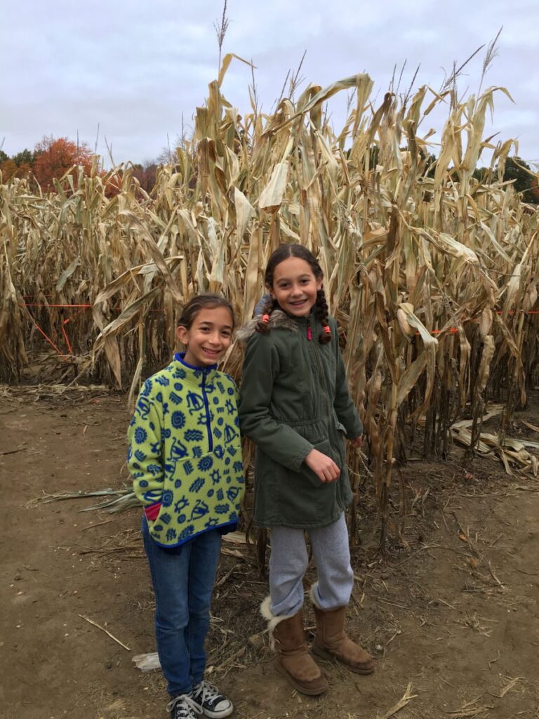 2 girls next to corn maze